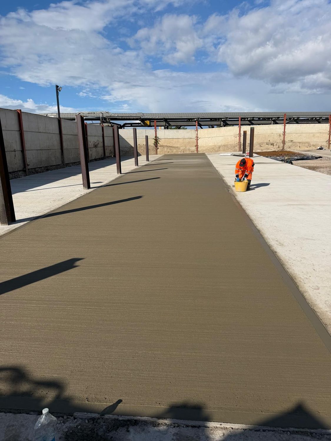 Fresh concrete levelled between steel posts