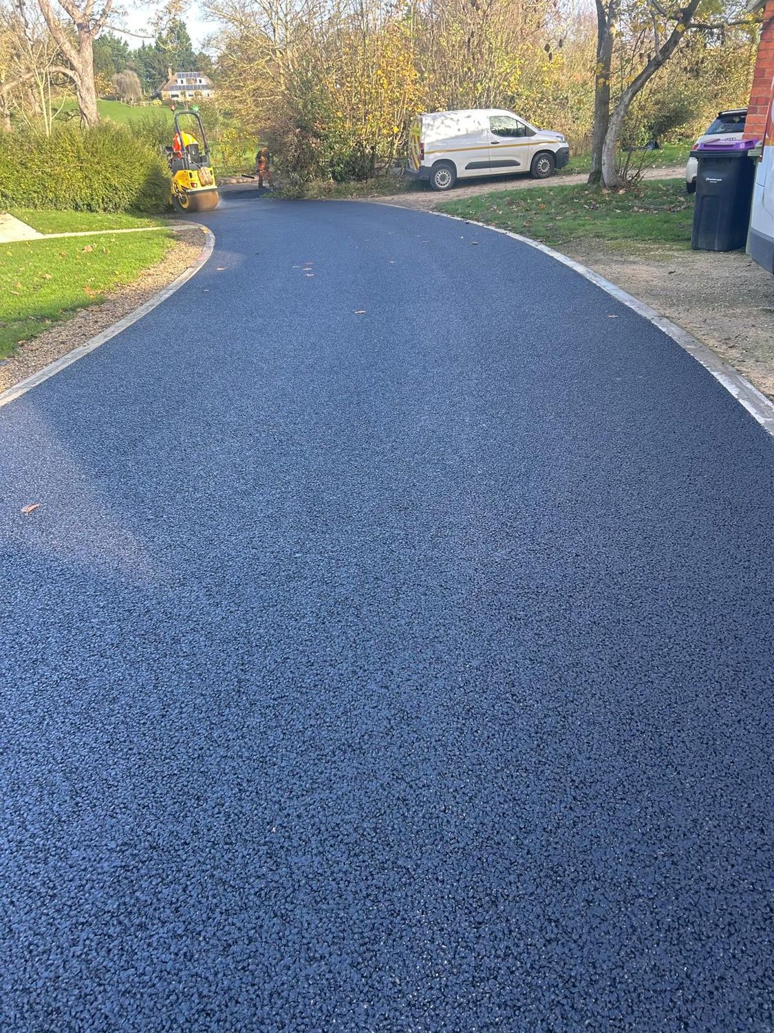 Newly laid tarmac access road with kerb edging