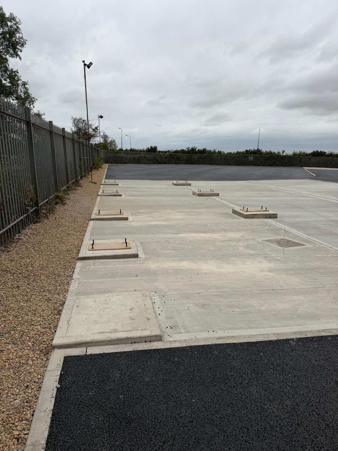 Concrete slab with cast bases beside the tarmac surfacing