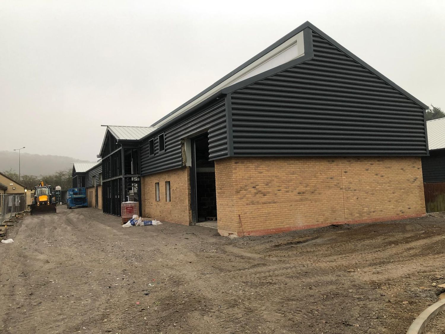 Completed unit with brick plinth and dark profiled cladding