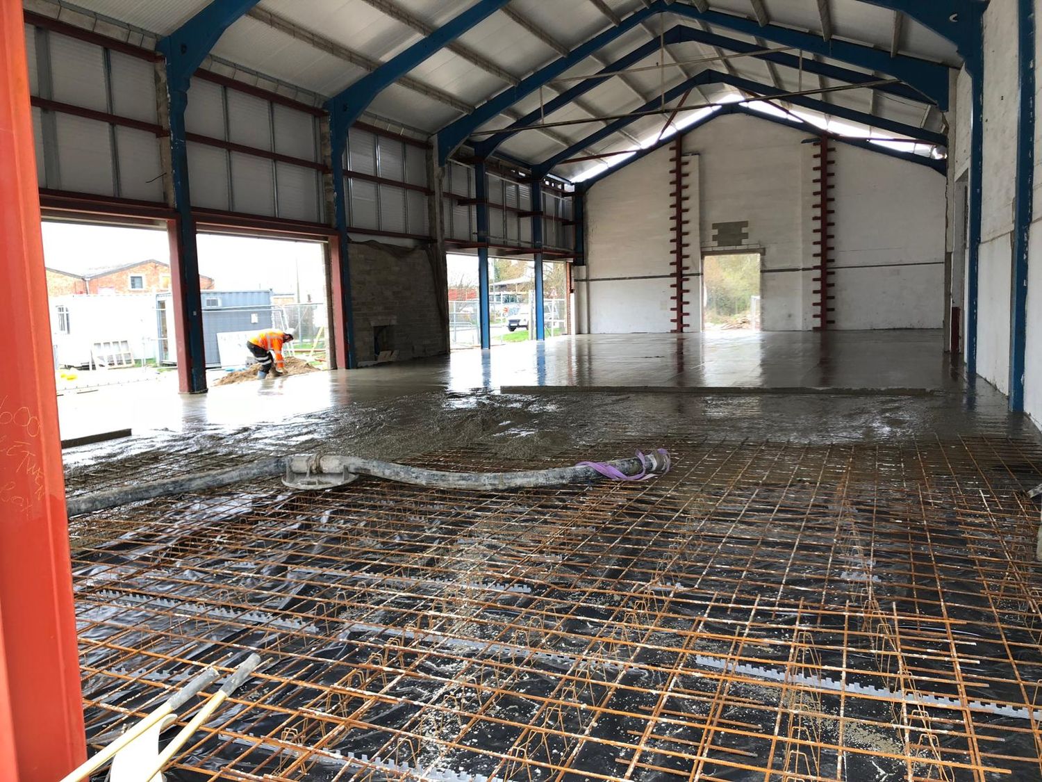 Floor slab pour in progress over mesh reinforcement